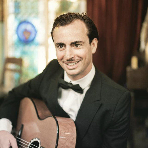 Headshot of Charlie Roman playing guitar