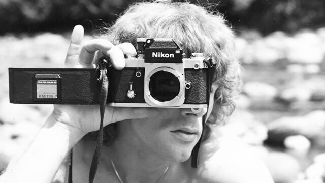 Black and white photo of a young Dustin Pittman holding a camera.