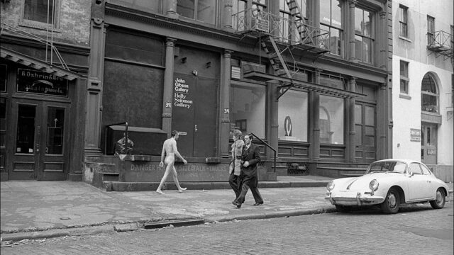 A naked man walks up West Broadway in Soho, photograph by Allan Tannenbaum.