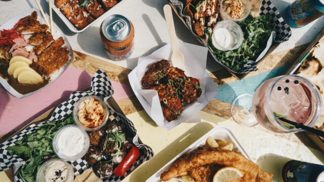 A selection of take-away meals and drinks laid out on a table.