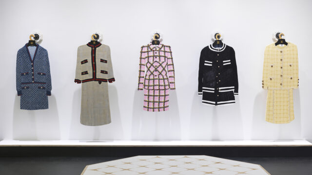 Installation view of Tom Sachs’ 31 Rue Cambon, featuring five CHANEL-inspired skirt suits displayed against a white gallery wall.