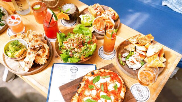 Flatbread, lobster rolls and guacamole served at Gilligan's on a wooden table