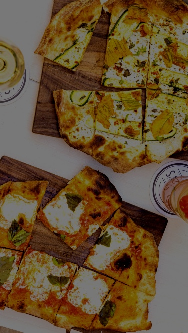 Pizzas on wooden boards at Gilligan's outdoor bar and restaurant in SoHo, NY.