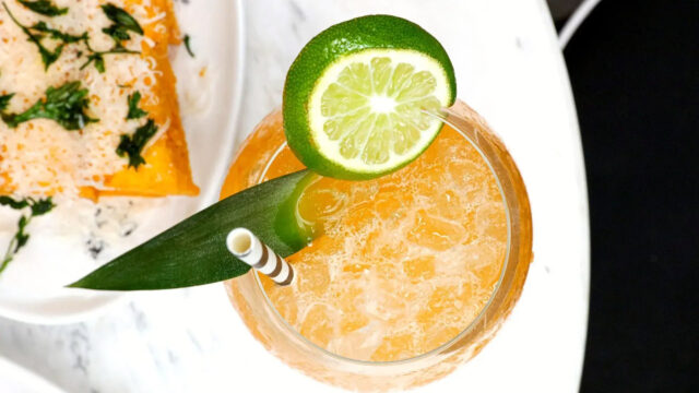 Cocktail on ice with lime and green garnish at Roxy Café in Tribeca.