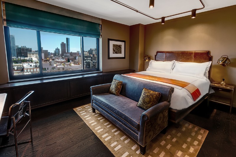 Grand Corner King bedroom with a couch and desk and view of the manhattan skyline