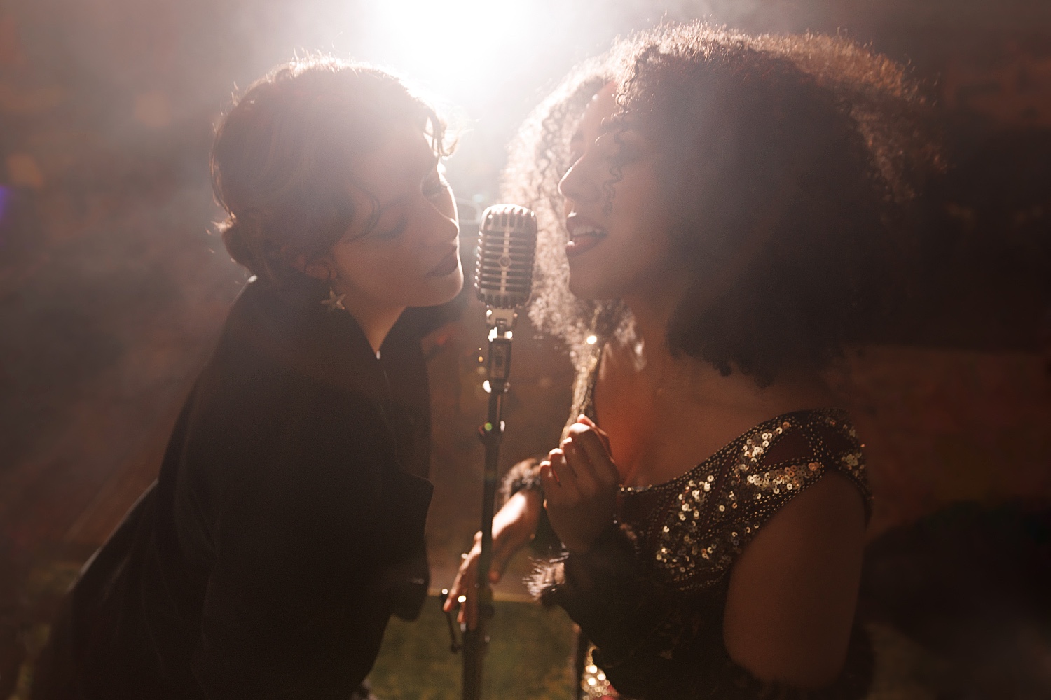 Two women singing into a microphone at Club Room.