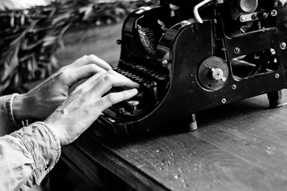 a man types on an old-fashioned typewriter