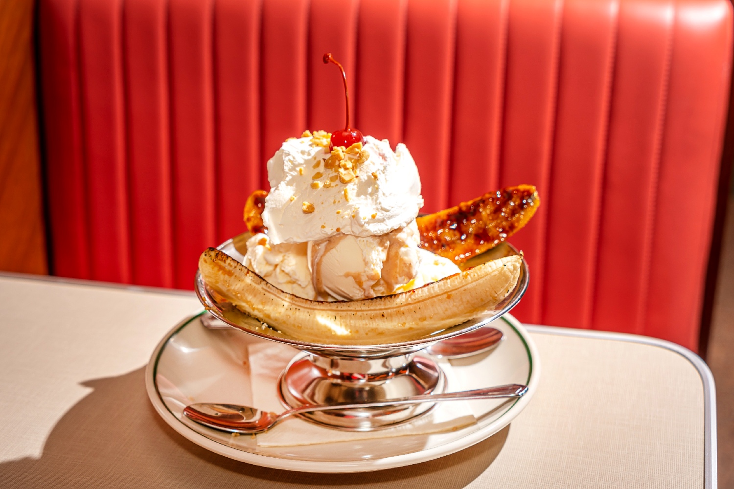 Banana Split in a silver serving bowl with whipped cream and a cherry on top at Soho Diner.