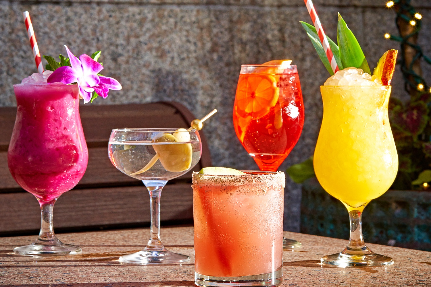 An assortment of summer cocktails lined up on an outdoor table at Soho Diner.