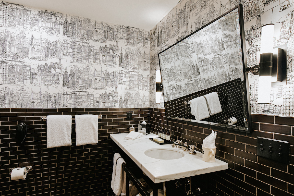 Terrace Suite bathroom with black subway tiling and ornate black and white wallpaper