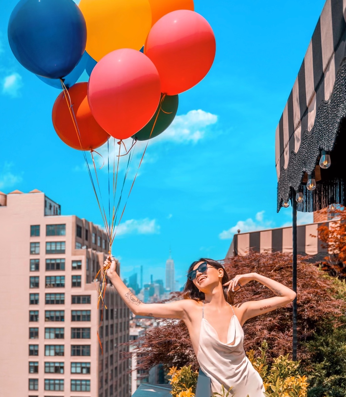 Woman holding balloons on a terrace at Soho Grand Hotel.