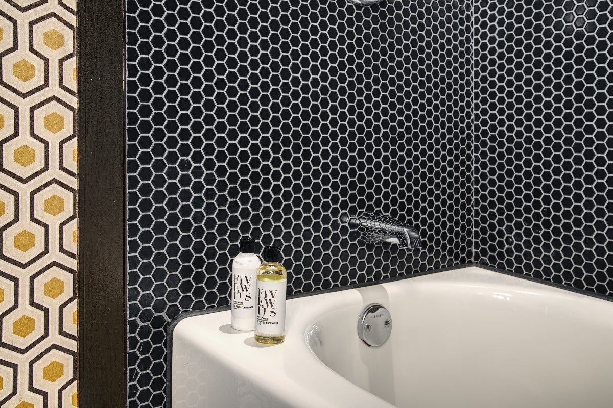 Roxy Hotel black tile and white tub bathroom.