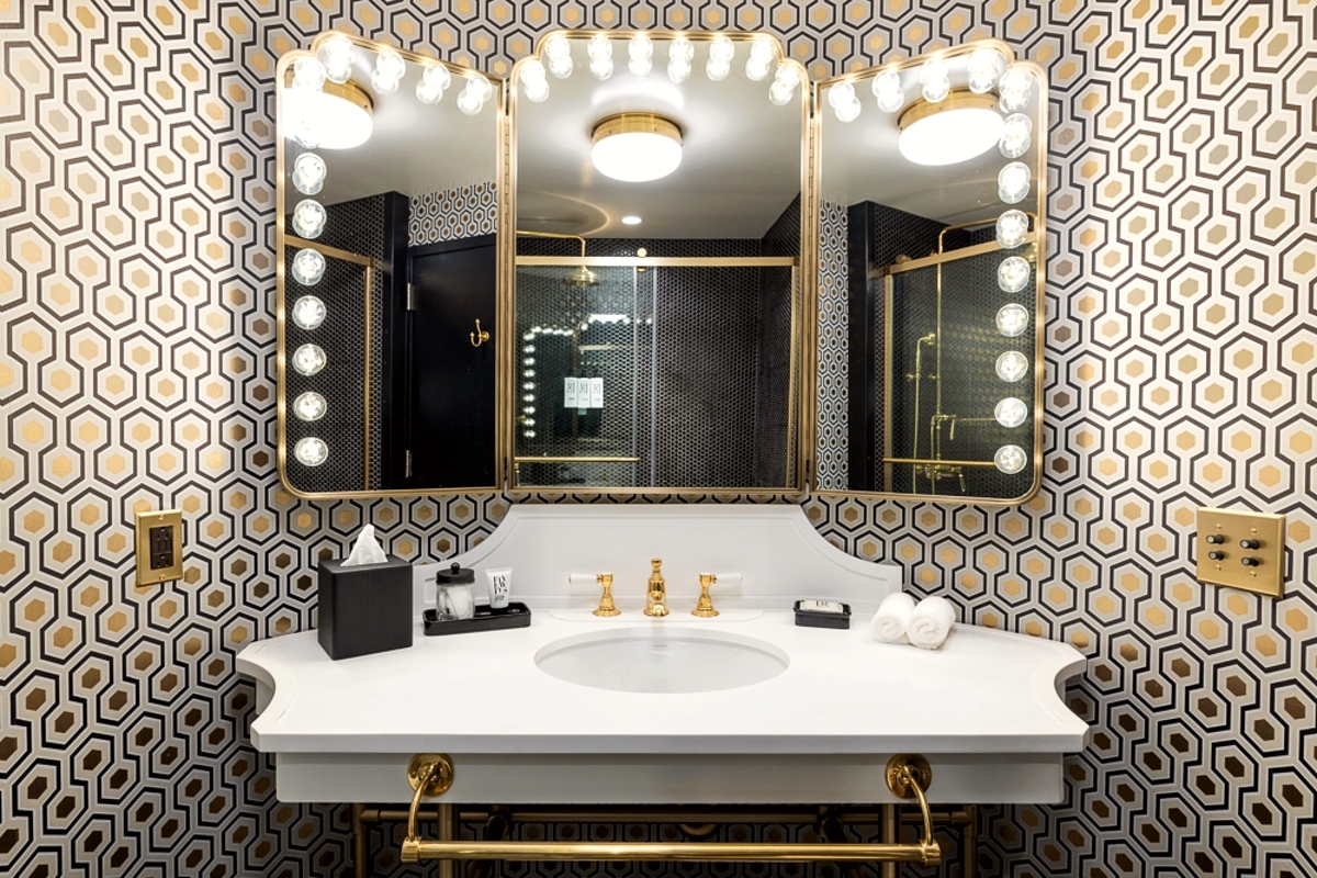 Bathroom vanity with stage bulb lighting and a white sink.