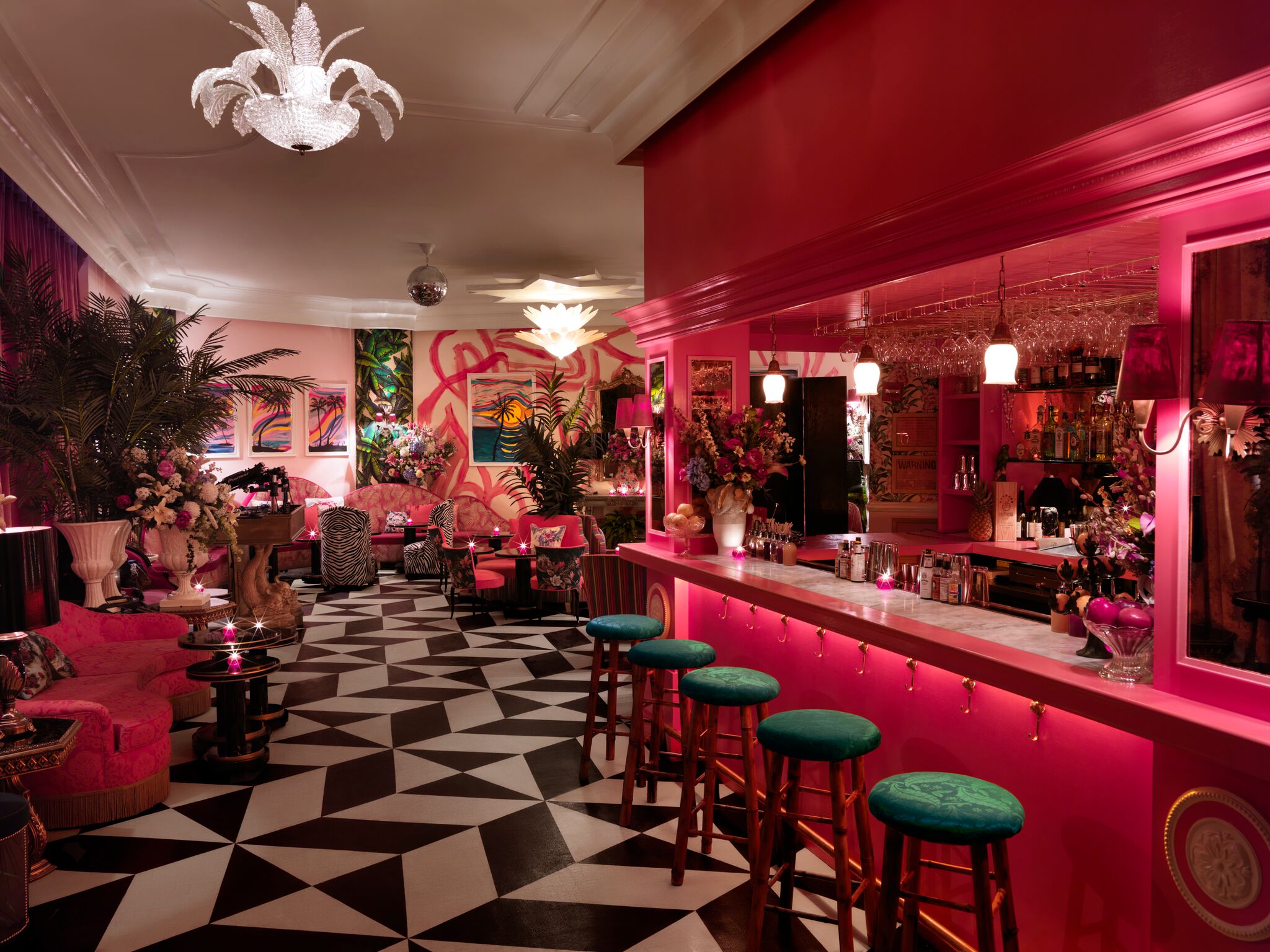 a colorful cocktail lounge with a hot pink bar and black and white patterned accents