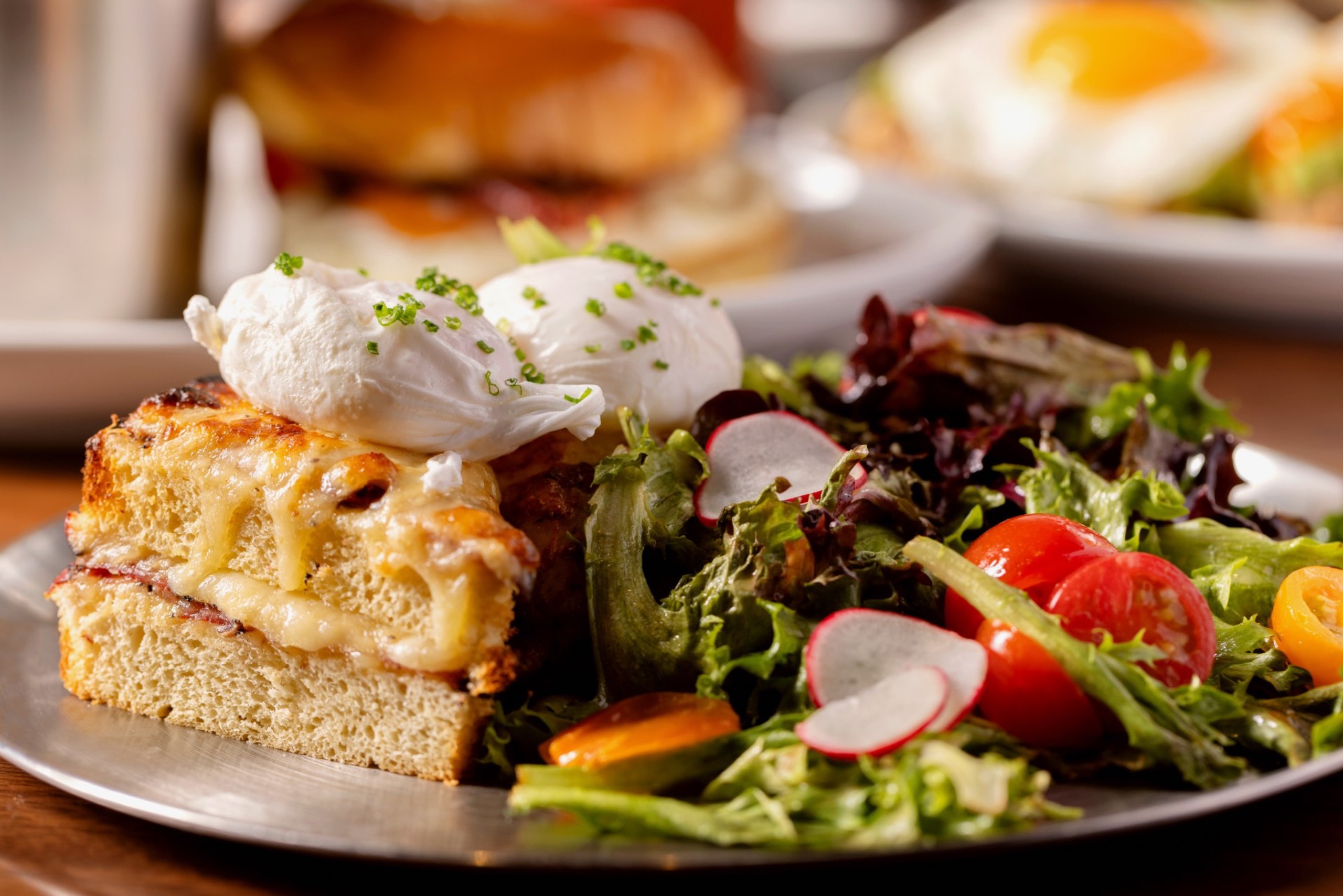 Closeup of Croque Madame sandwich with salad.