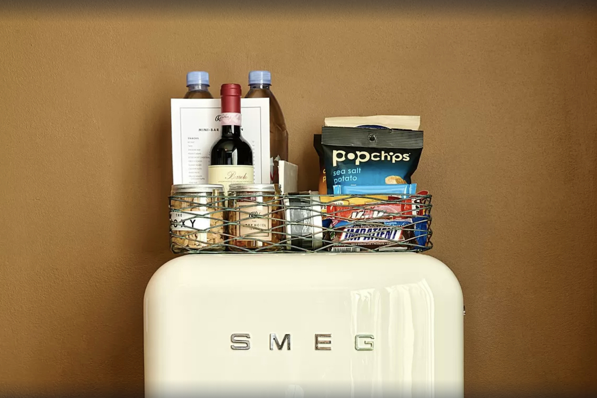 detail shot of a white smeg refrigerator with mini bar snacks on top