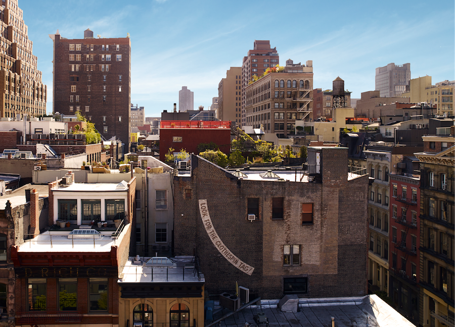 a cityscape with many buildings and rooftops under a blue sky