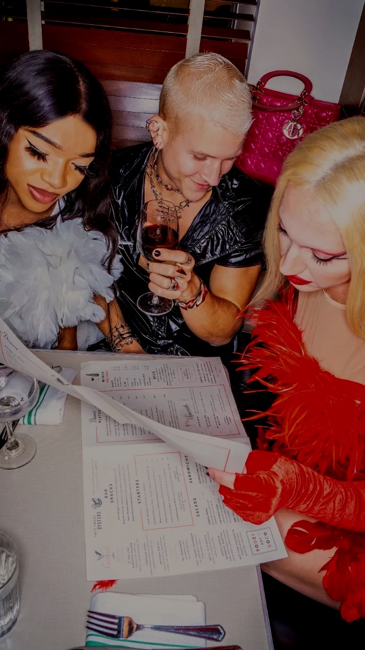 Three fashionable friends looking at the menus at Soho Diner.