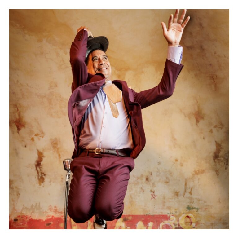 Musician Chino Pons jumping up in the air on stage at The Django.