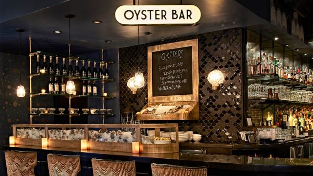Roxy Bar Oyster bar seating with oysters on ice and a chalkboard menu of daily specials.