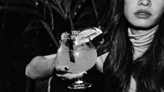 Photo of a woman holding a large margarita