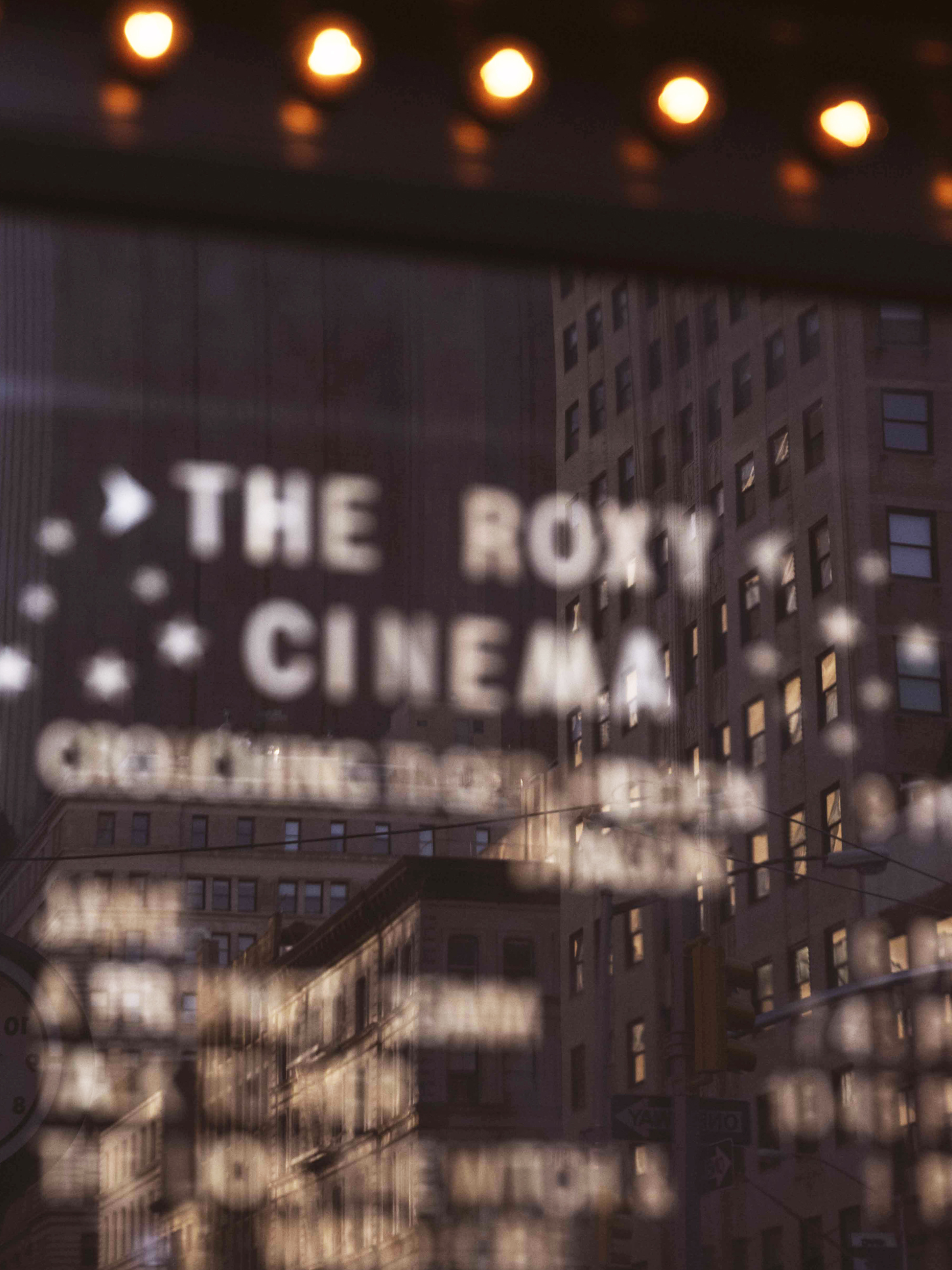 a reflection of the tribeca neighborhood skyline against the roxy cinema new york's screenings board