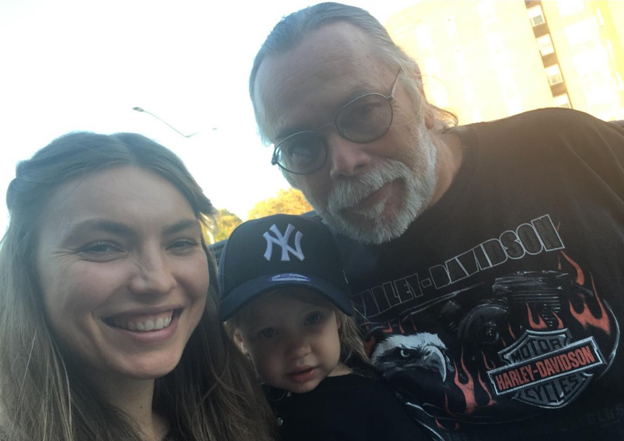 Man, young woman and child posing for a picture together.