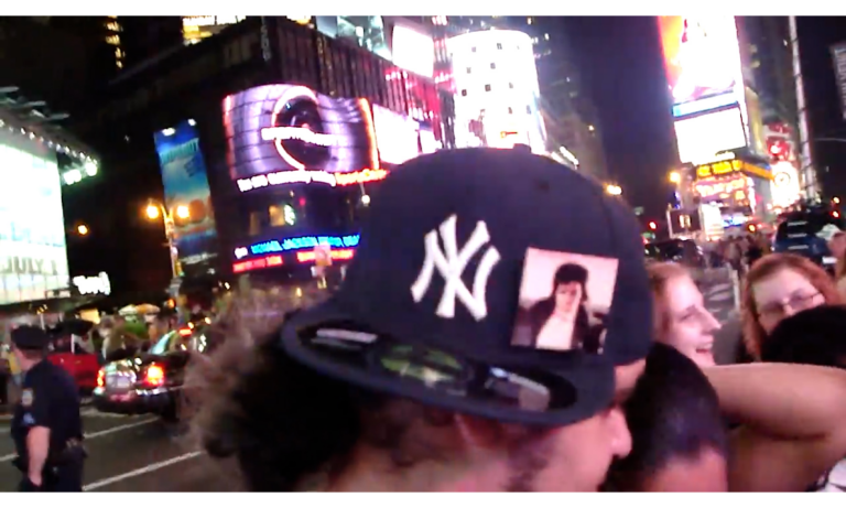 film still from There'll Likely be Michael Jackson Vigils Throughout the Night, Yankee hat with MJ icon