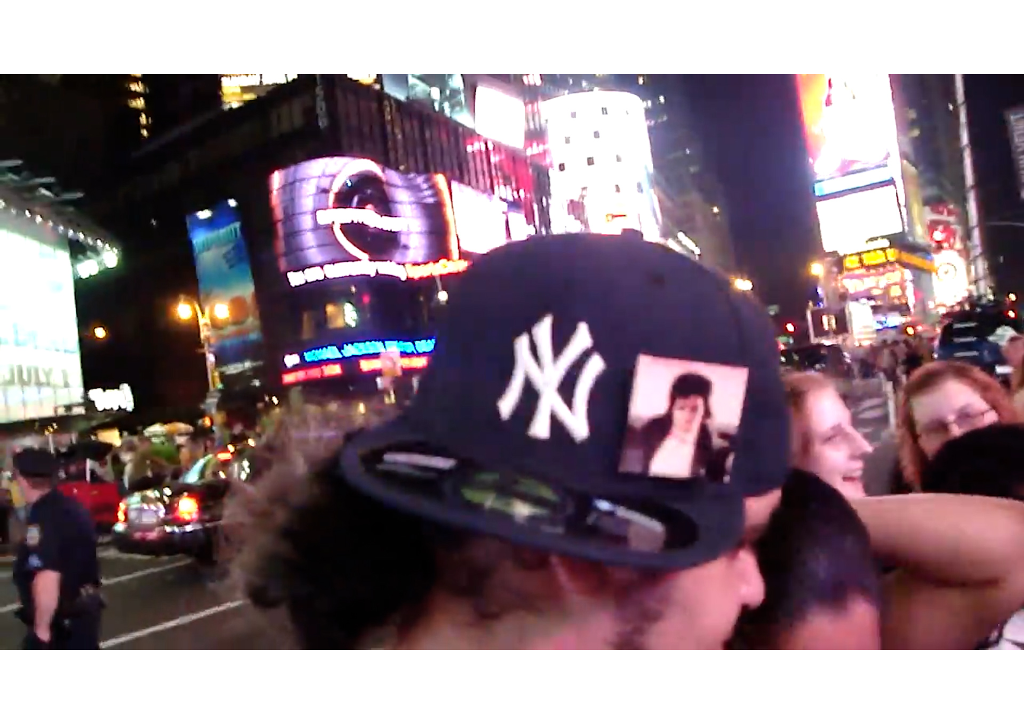 film still from There'll Likely be Michael Jackson Vigils Throughout the Night, Yankee hat with MJ icon