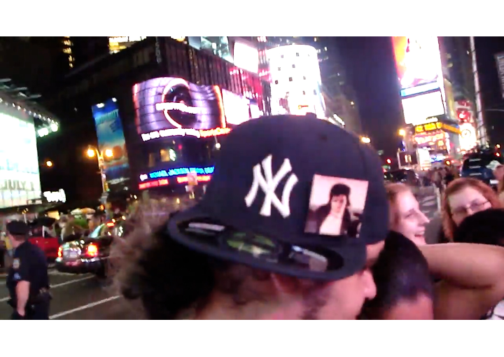 film still from There'll Likely be Michael Jackson Vigils Throughout the Night, Yankee hat with MJ icon