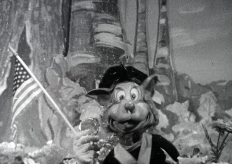 Topsy Turvey film still, puppet holding American Flag