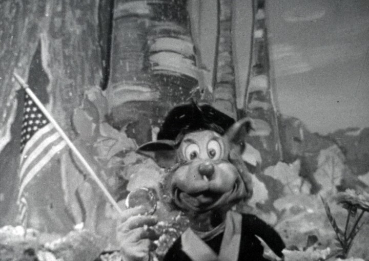 Topsy Turvy film still, puppet holding American Flag